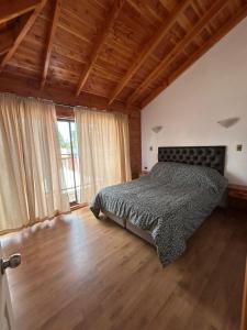 a bedroom with a bed and a wooden floor at cabañas los Ulmos in Licán Ray +63 photos