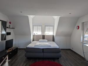 Landhaus Hotel Müller في Ringheim: غرفة نوم صغيرة مع سرير وتلفزيون