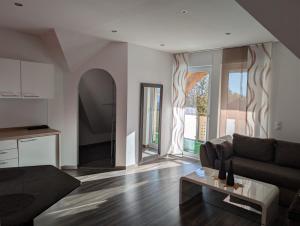 Landhaus Hotel Müller في Ringheim: غرفة معيشة بها أريكة وطاولة +25 صورة