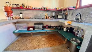 a small kitchen with a counter with a microwave at Casa Beira rio Caraíva in Porto Seguro