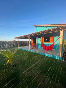 a house with a hammock in the yard at Casa Beira rio Caraíva in Porto Seguro