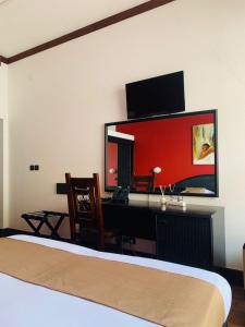 Un dormitorio con una cama y un escritorio con una computadora. en Hotel Dunas Boavista, en Sal Rei