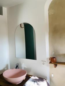 ein Badezimmer mit einer rosa Schüssel auf einem Holztisch in der Unterkunft Chambre au calme in Reillanne