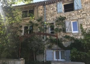ein altes Steinhaus mit einem Tor davor in der Unterkunft Chambre au calme in Reillanne