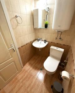 ein kleines Badezimmer mit Toilette und Waschbecken in der Unterkunft Vasi City Stay in Weliko Tarnowo + 1 Foto