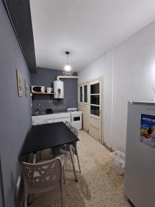 a kitchen with a table and chairs in a room at Nami in Necochea +2 photos