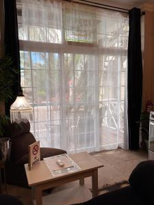a living room with a window with curtains and a table at Caye Caulker Boutique Guesthouse 2 in Caye Caulker