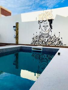 a mural on the side of a building with a pool at Villa Sabrina in Awlād ‘Umar