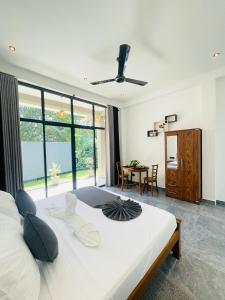 Un dormitorio con una gran cama blanca y una mesa. en Bella Nova, en Ahangama