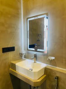 Un baño con un lavabo blanco y un espejo. en Bella Nova, en Ahangama