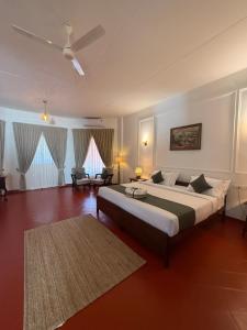 Ένα ή περισσότερα κρεβάτια σε δωμάτιο στο The Hundred House by Kisah Stays - Wayanad Colonial Estate Bungalow