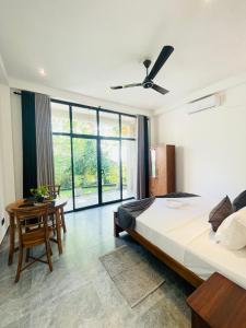 Un dormitorio con una cama grande y una mesa. en Bella Nova, en Ahangama