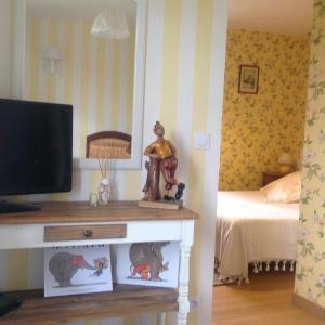 een slaapkamer met een bed en een televisie en een tafel bij L'Orchard in Bonneville-la-Louvet