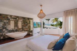 Villa MAEVA is your perfect beachfront escape في Roches Noires: حمام به سرير كبير وحوض استحمام +38 صورة