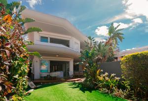 Villa MAEVA is your perfect beachfront escape في Roches Noires: منزل أمامه حديقة