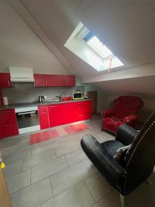 - une cuisine avec des placards rouges et une chaise dans la chambre dans l'établissement Casa Pesa - Olivone, à Olivone