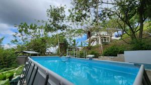 a swimming pool in front of a house at Edades Farms in Taysan