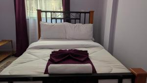 a bed with a bow on top of it at Zion Crest Suites - Kilimanjaro Helichrysum Homes in Arusha +17 photos