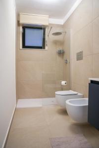 een badkamer met een douche, een toilet en een wastafel bij La Dimora di Lella in Aci Castello