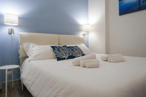 een groot wit bed met twee kussens erop bij La Dimora di Lella in Aci Castello