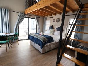 a bedroom with a loft bed and a table and a dining room at Calypso Sunset in Langebaan