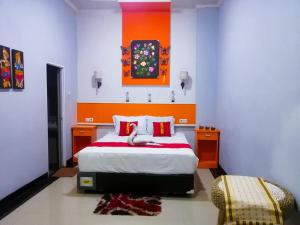 a bedroom with a bed with an orange and blue wall at Hotel Grand illa palopo in Palopo