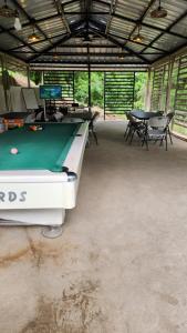 un tavolo da biliardo in un garage con tavoli e sedie di Edades Farms a Taysan