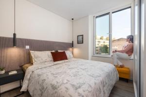 a woman sitting on a bench in a bedroom at Boutique in Funchal