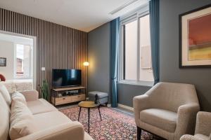 a living room with a couch and chairs and a television at Boutique in Funchal