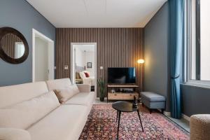 a living room with a white couch and a television at Boutique in Funchal +41 photos