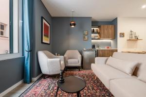 a living room with a couch and chairs and a kitchen at Boutique in Funchal
