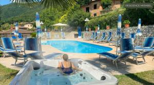 Residence Mirabel في تينيالي: وجود امرأة في حوض استحمام ساخن بجانب مسبح