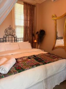 a bedroom with a bed with a mirror and a window at Caye Caulker Boutique Guesthouse 3 in Caye Caulker