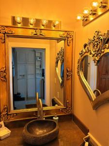 a bathroom with a sink in front of a mirror at Caye Caulker Boutique Guesthouse 3 in Caye Caulker