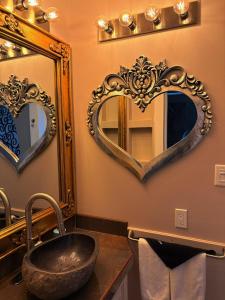 a bathroom with two heart shaped mirrors and a sink at Caye Caulker Boutique Guesthouse 3 in Caye Caulker