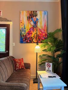 a living room with a couch and a painting on the wall at Caye Caulker Boutique Guesthouse 3 in Caye Caulker