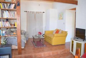 Les Hirondelles BED&BREAKFAST في بيريابوليس: غرفة معيشة مع أريكة صفراء وطاولة