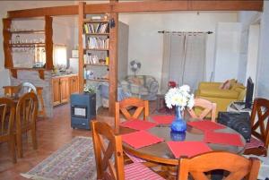 Les Hirondelles BED&BREAKFAST في بيريابوليس: غرفة معيشة مع طاولة مع إناء من الزهور