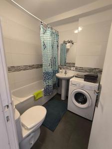 a bathroom with a toilet a sink and a washing machine at Garden City apartment in Costa de Adeje +10 photos