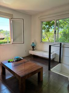 a room with a bench and a table and windows at La Variopinta in Punta del Este