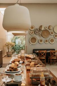 a table topped with plates of food on top at Hotel Amantykir in Itajubá