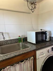 a kitchen with a sink and a microwave at La Variopinta in Punta del Este