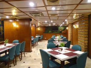 a dining room with tables and chairs and a screen at Hotel Galaxy in Karachi