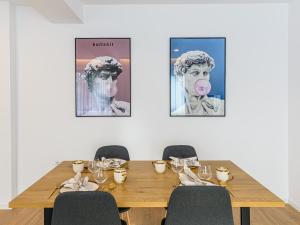 Ein Tisch mit Stühlen und ein Bild einer Frau mit rosa Zunge in der Unterkunft KOA - Davino Aparthotel in Braşov