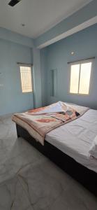 a large bed in a room with two windows at Royal inn in Patna