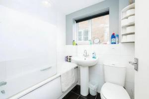 Un baño blanco con lavabo e inodoro. en 2 Bedroom House For Corporate Stays in Kettering, en Kettering