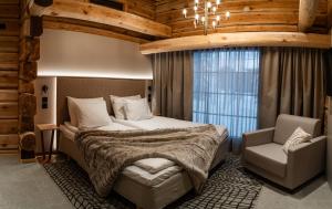 ロヴァニエミにあるVaattunki Wilderness Resortのベッドと椅子のある寝室