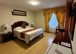 a bedroom with a bed and a wooden floor at Hotel Britania San Borja in Lima