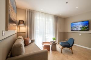 a living room with a couch and a blue chair at Hotel Beit Shmuel in Jerusalem