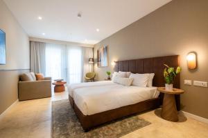 a bedroom with a large bed and a chair at Hotel Beit Shmuel in Jerusalem